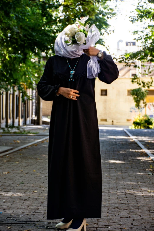 a lady dressed in a long black dress and a large headpiece