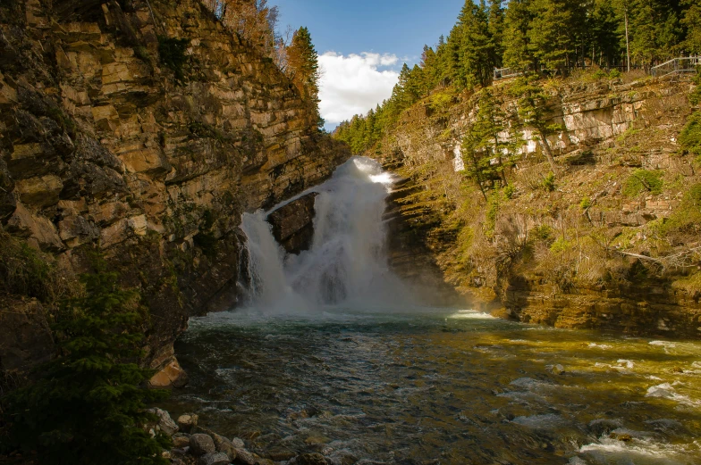 a waterfall cascading over a river between two large rocks
