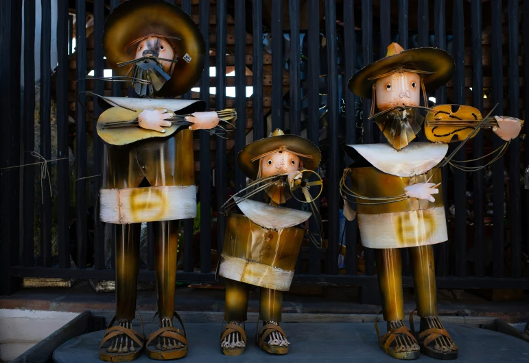 some metal figures playing musical instruments on the sidewalk