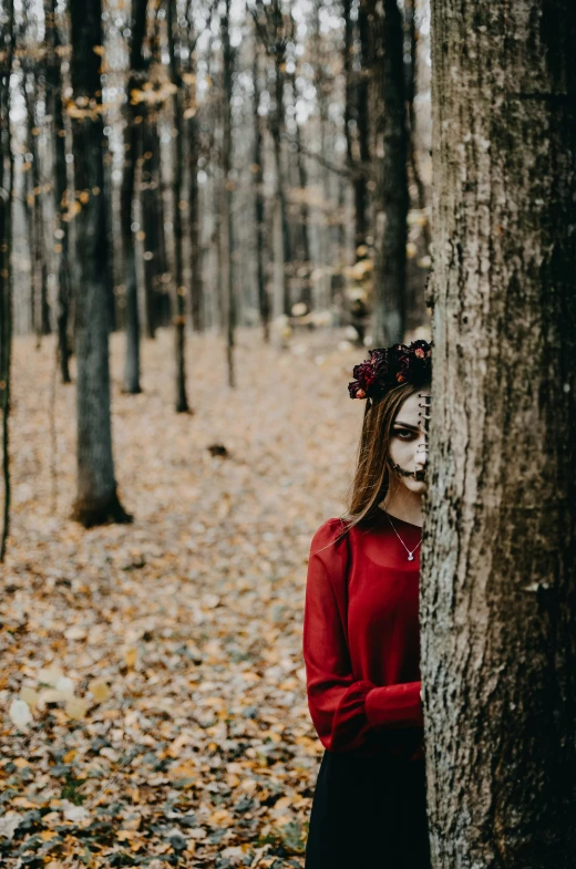 a woman in a red shirt standing next to a tree