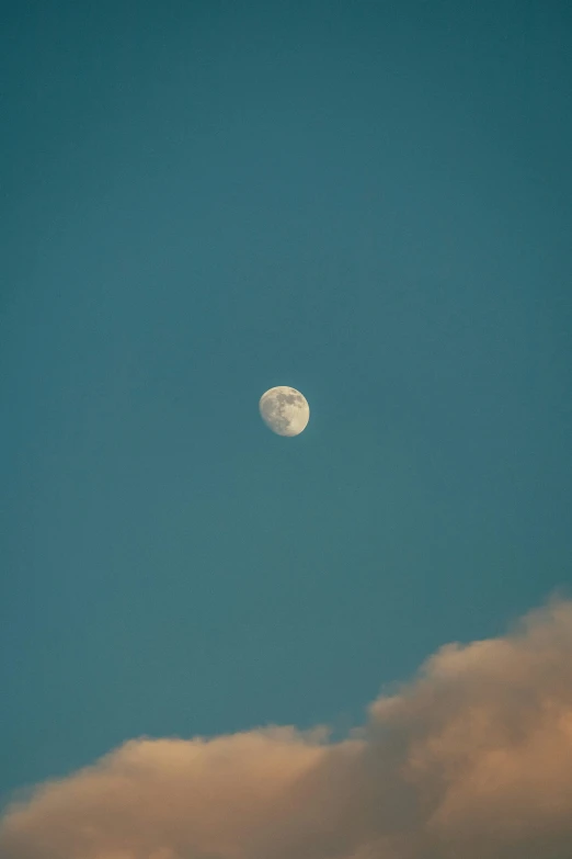 the moon shining brightly through a cloudy sky