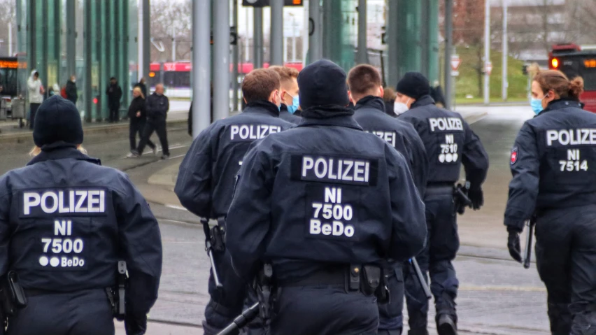 group of police men walking along a road in a metropolitan area