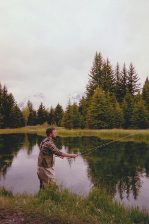 a man that is standing in the grass with a fish