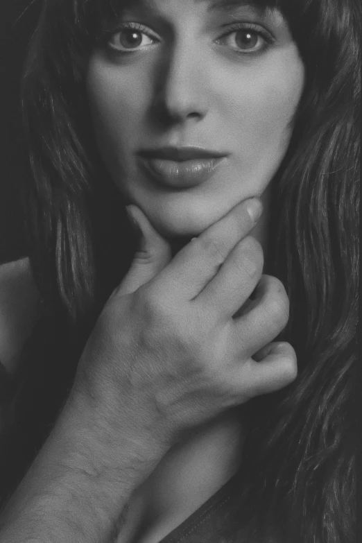 a woman posing with her hands under her chin