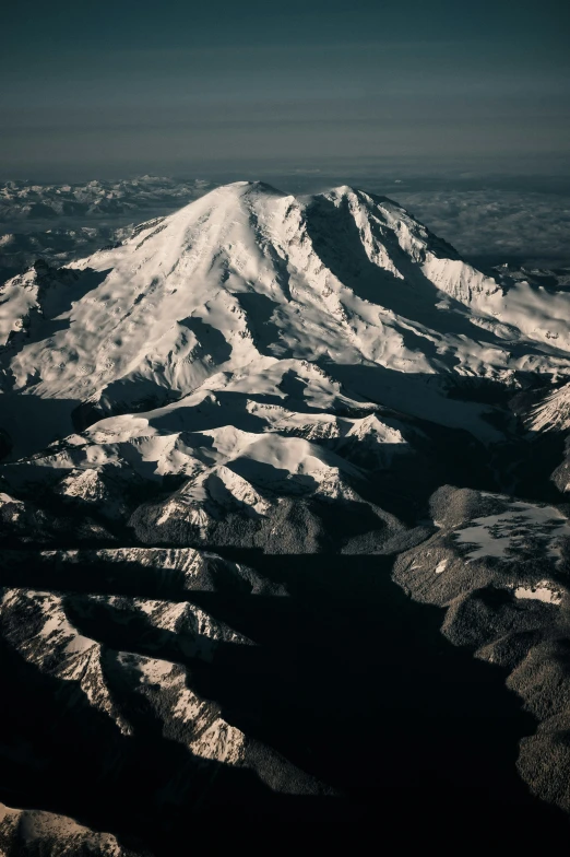 the snow covered mountain range is seen from a plane window