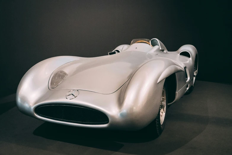 a silver race car sitting on top of a floor