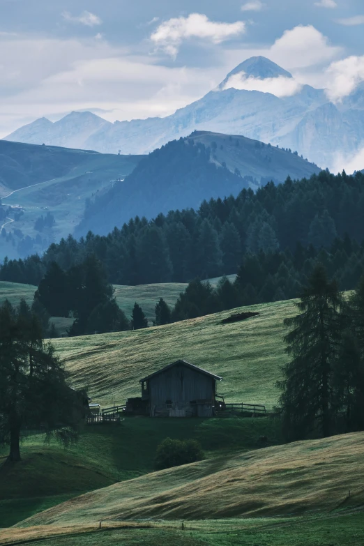 an old barn sits on the side of the hill