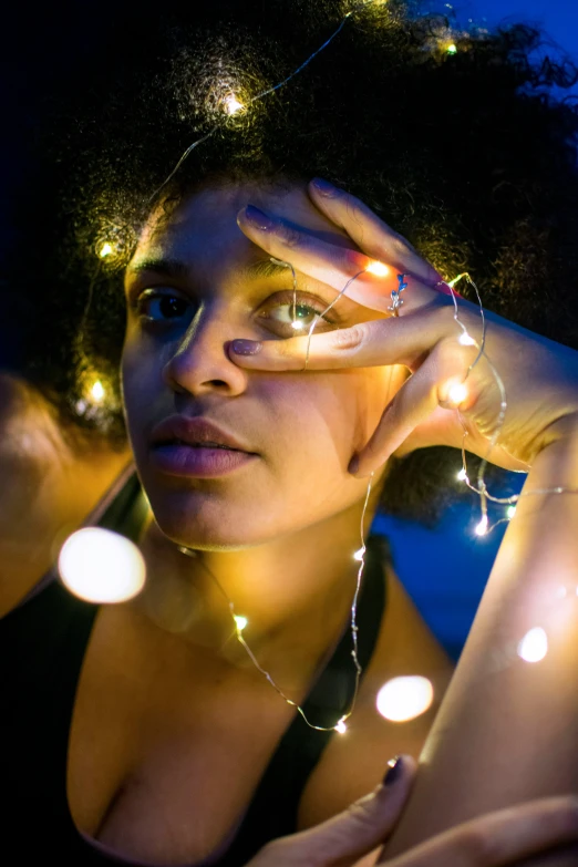 a woman posing with string lights on her head