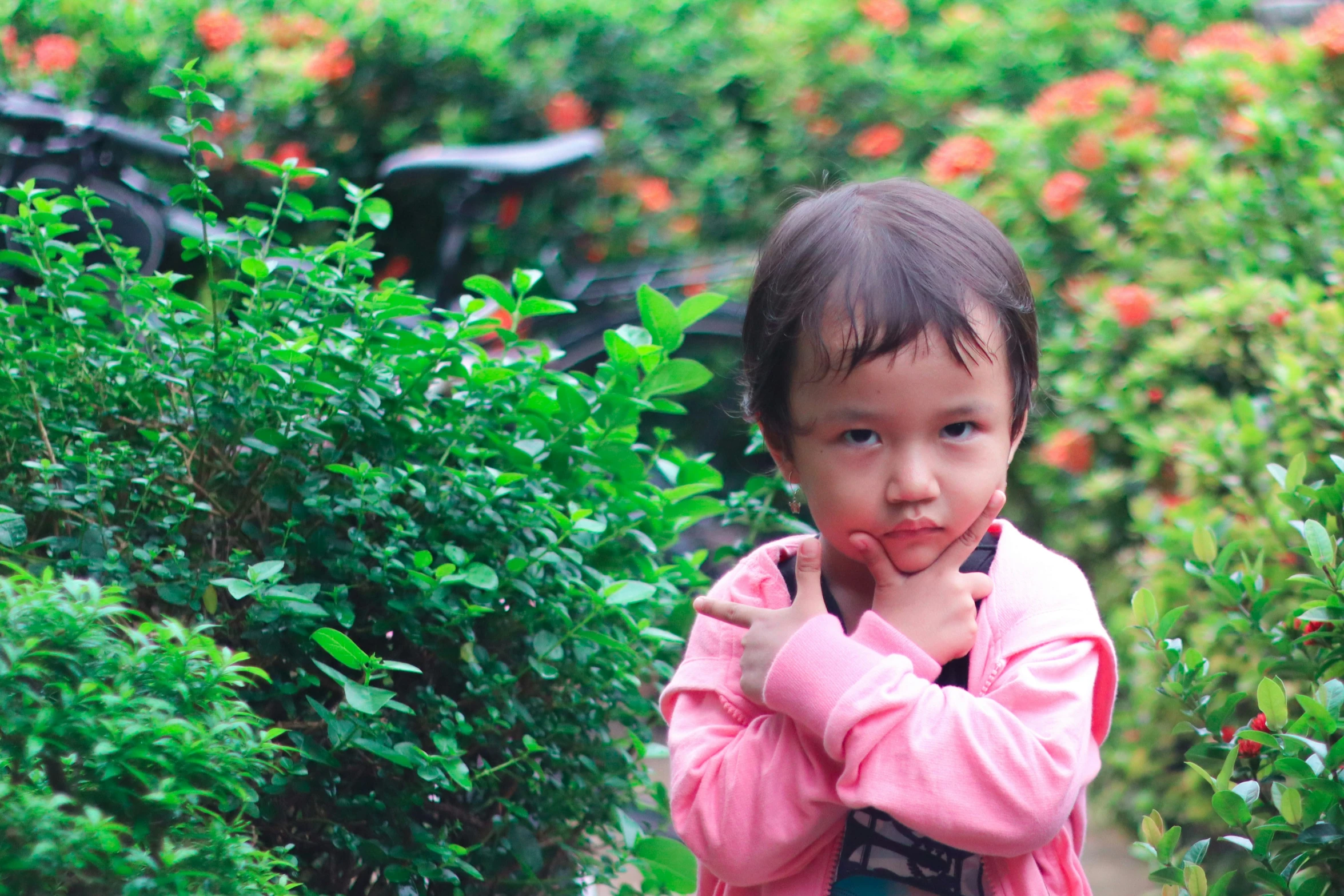 a little asian girl is in a garden