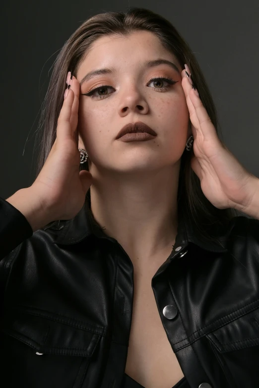 a beautiful woman with dark makeup is posing for a picture