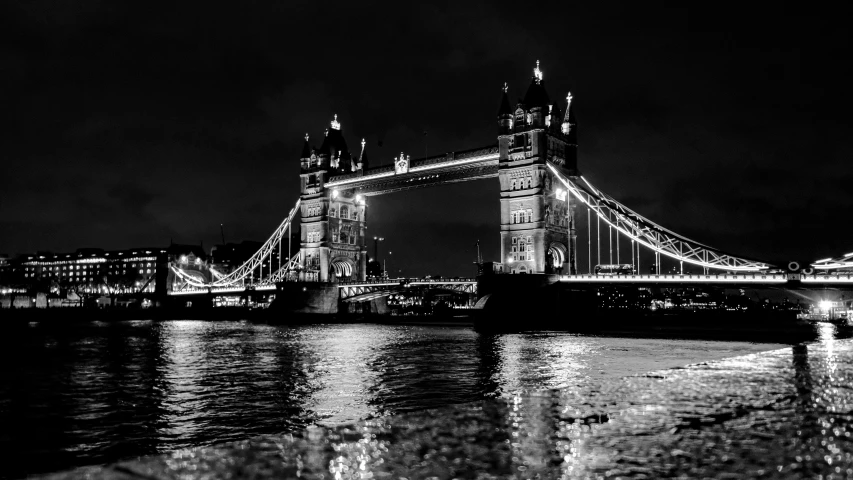the tower bridge over water at night