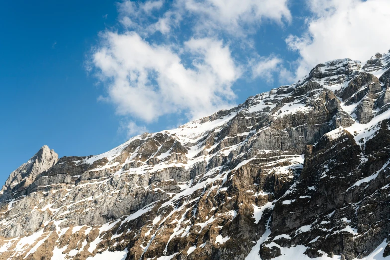 a mountain side with some very steep sides covered in snow