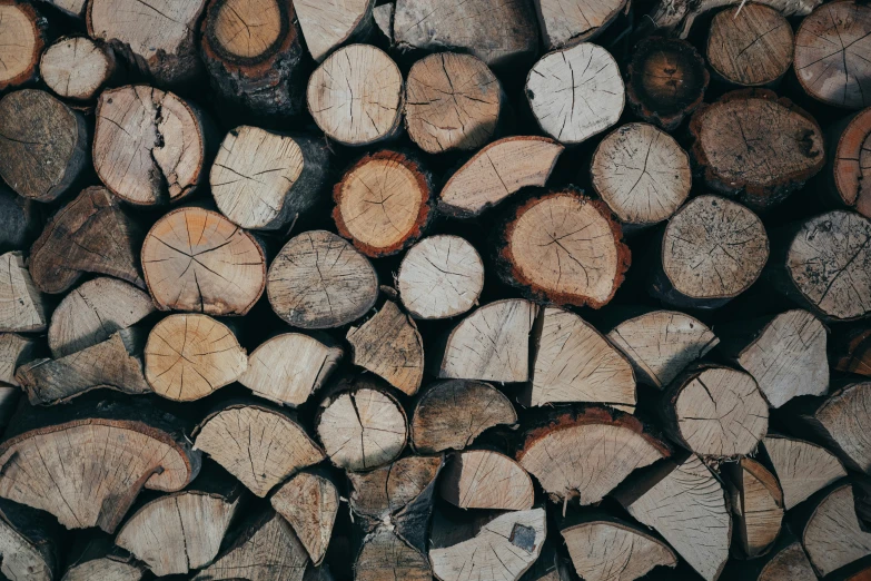 the wooden logs are piled on top of each other