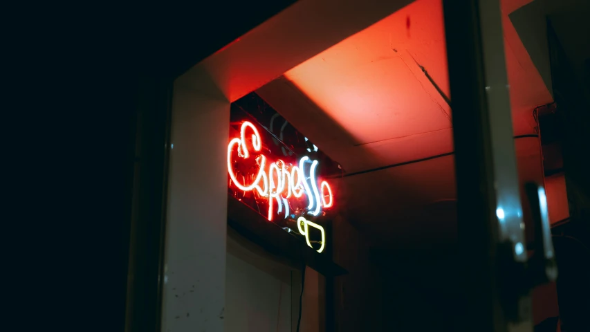 a neon sign sits on the side of a building