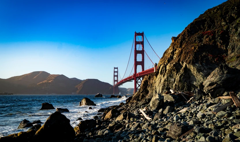 golden gate bridge with rocky shore in the foreground