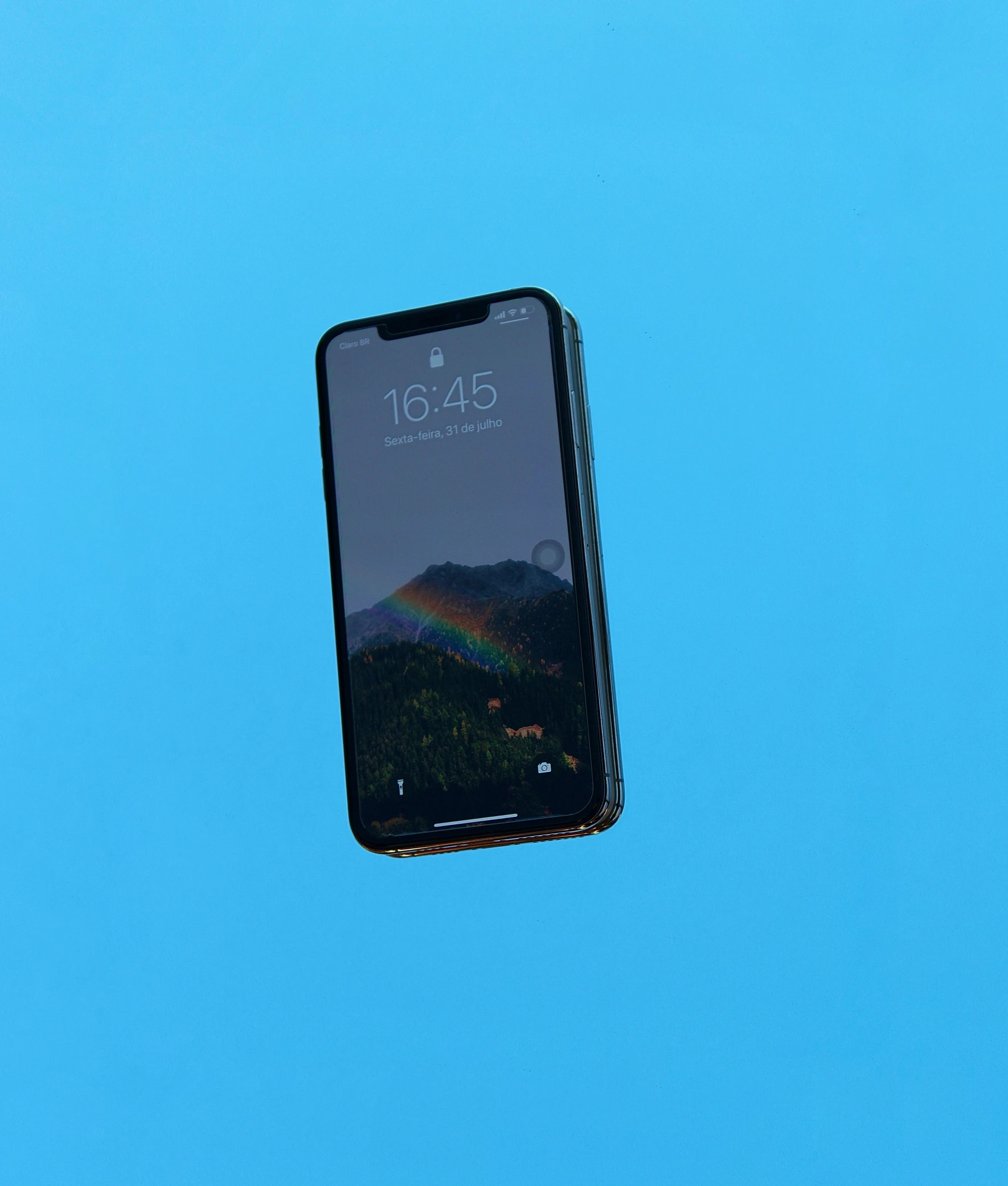 a smartphone is suspended above the camera on a blue background