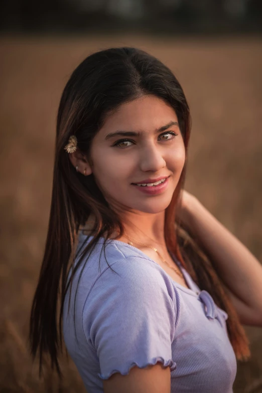 a pretty young lady with long hair in a field