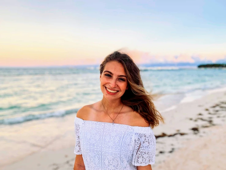 a woman with her hair blowing in the wind on a beach