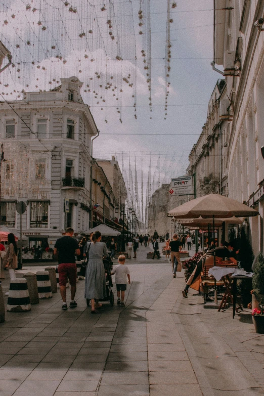 people walking down the street holding an umbrella