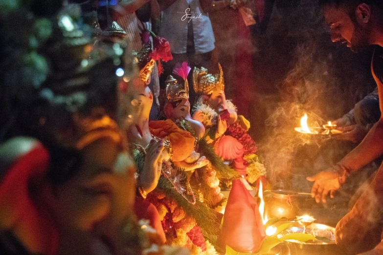 people gathered around and holding candles while standing next to each other