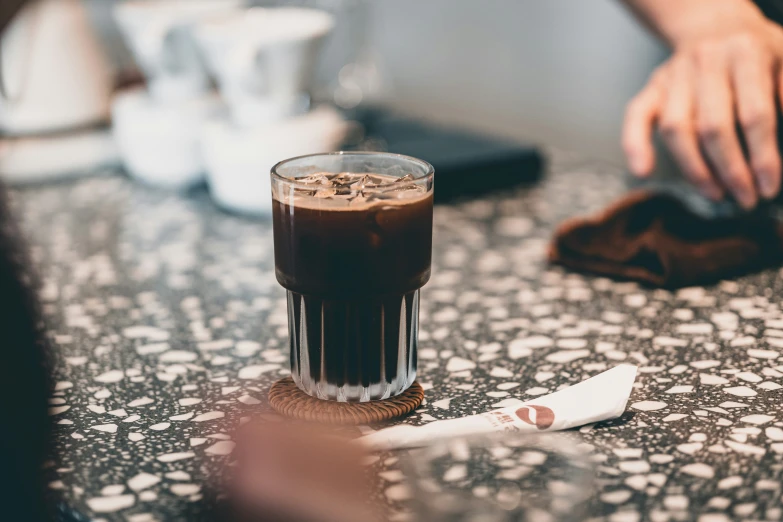 a glass of soda sitting on top of a table next to a toothbrush