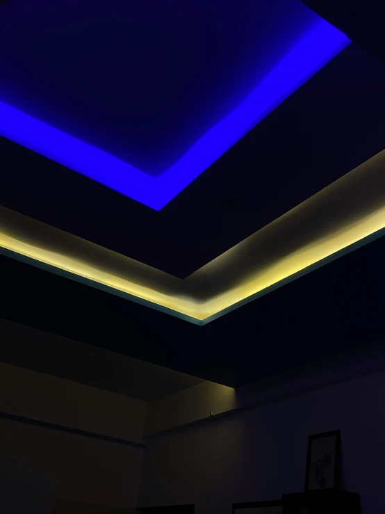 an empty room with a skylight and some blue lights