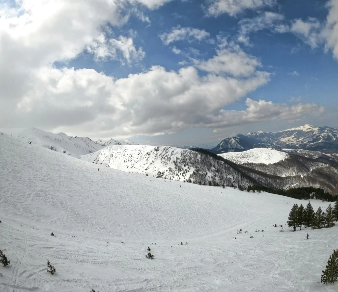 clouds hang over a mountain covered in snow