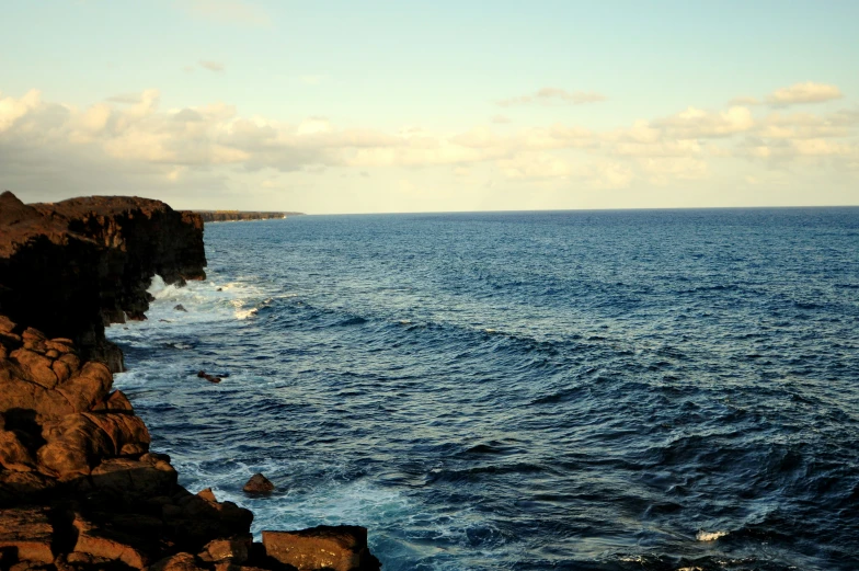 some people on a cliff above the ocean