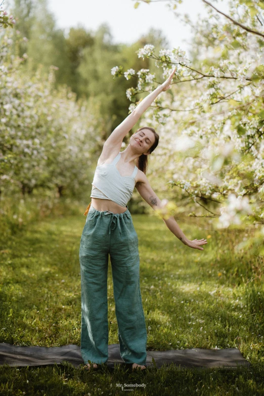 a woman standing on a wooden object in front of trees