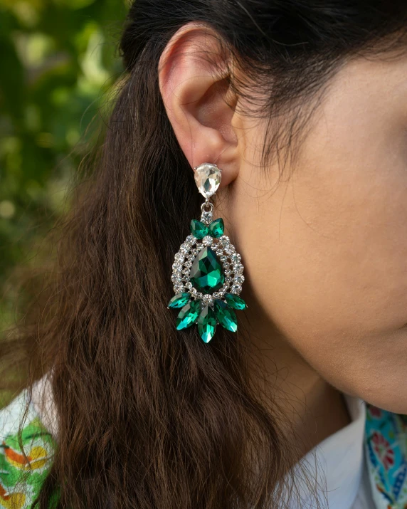 an asian woman with a green flower earrings