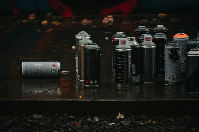 a group of cans and lighters sitting on a surface