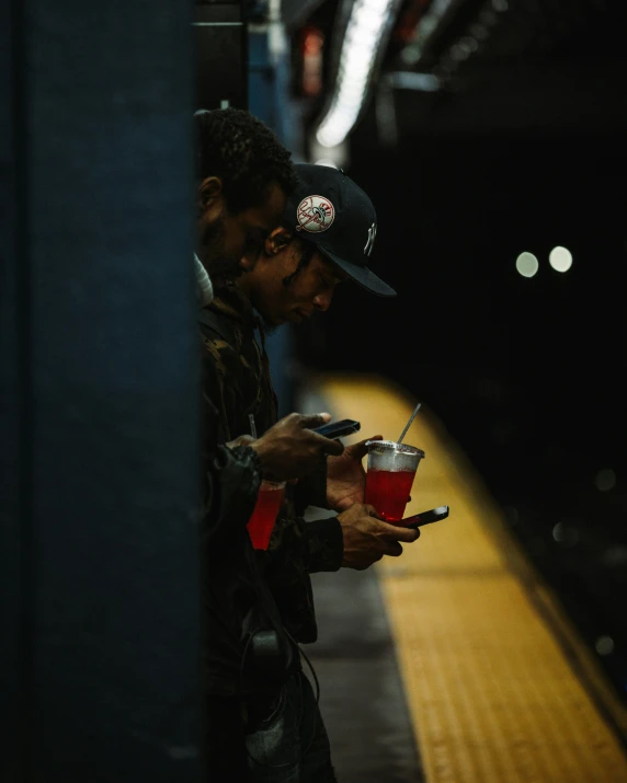 a man holding a drink while on a subway train