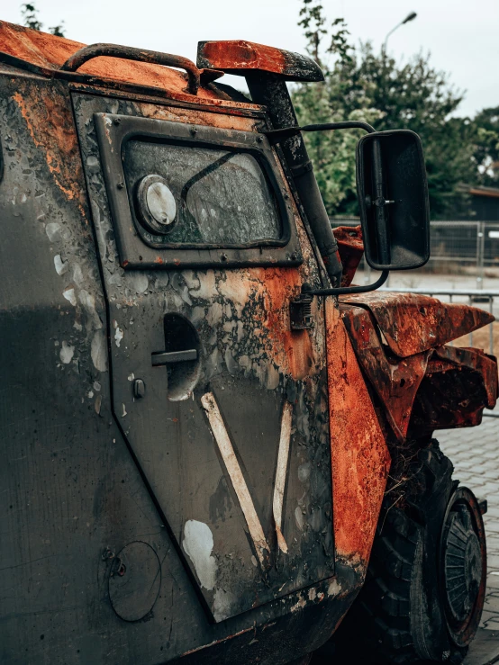 an orange army vehicle, with lots of rust on it