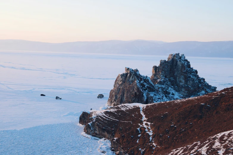 snow capped rocks on top of a hill