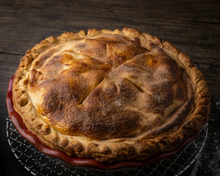 a baked pie sitting on top of a metal rack