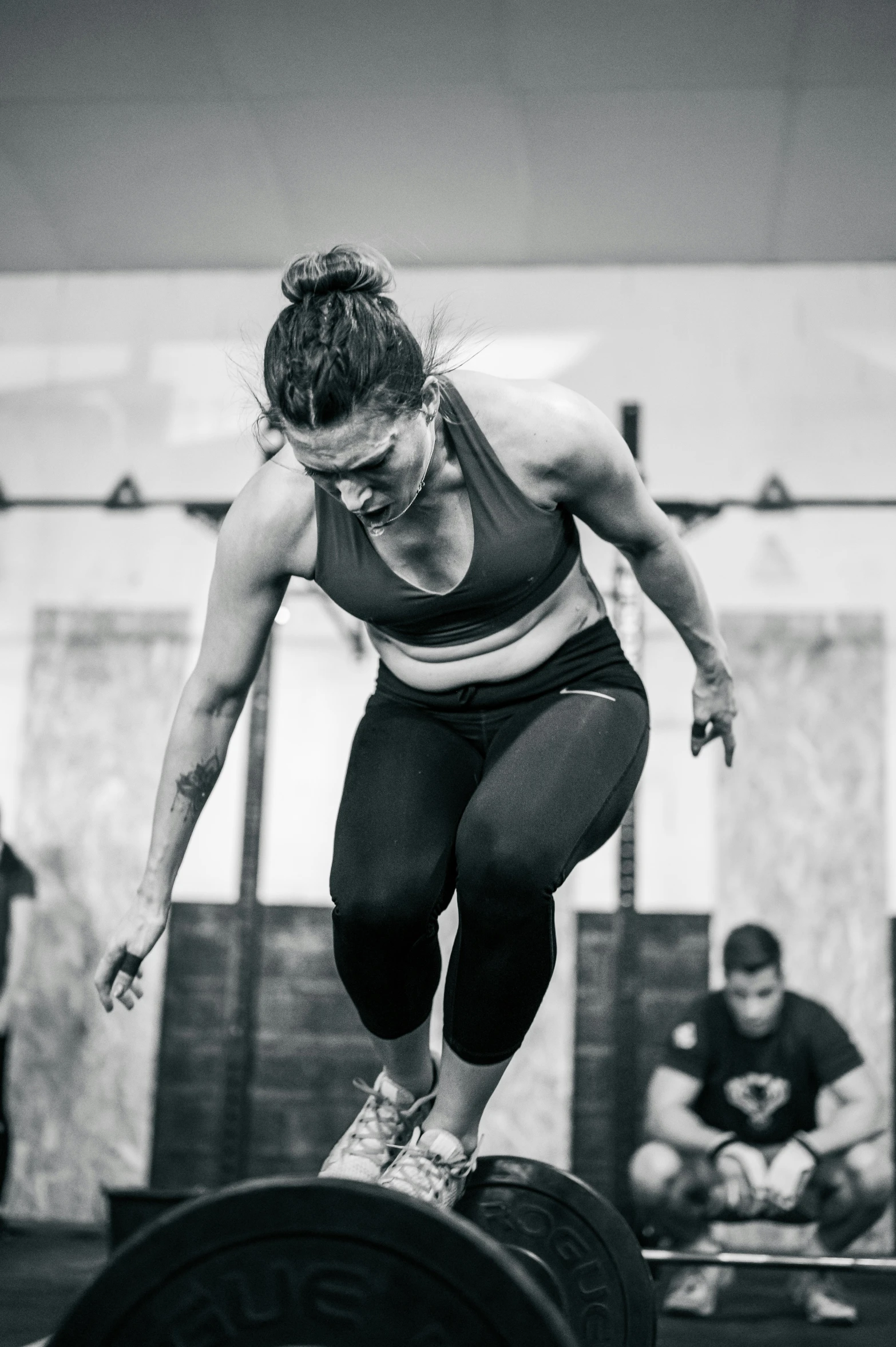 black and white pograph of a woman doing a barbell squat