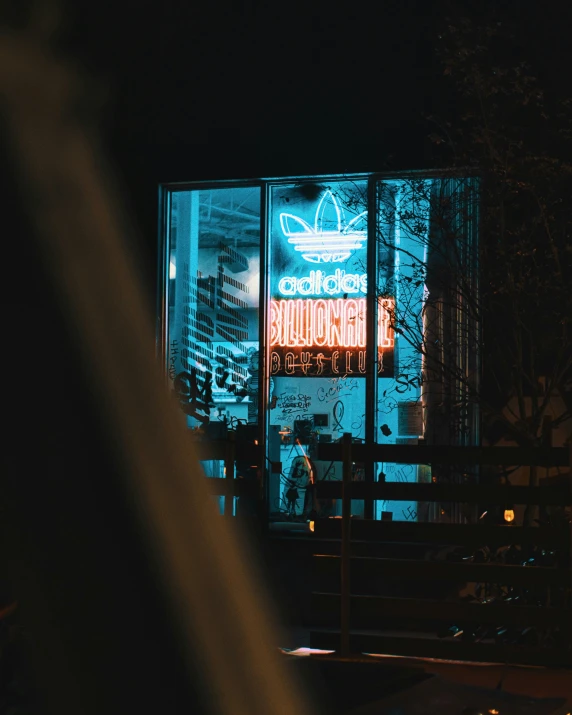 a person walking outside of a building lit up at night