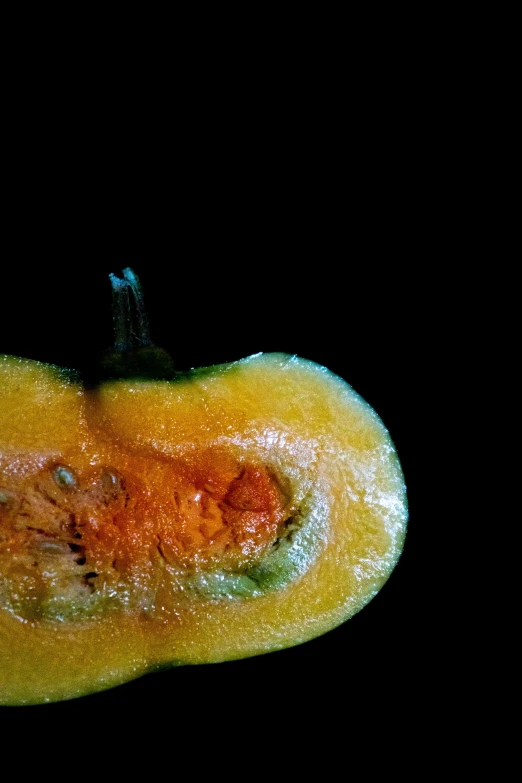 a long, yellow pepper with an extremely orange peel on the side