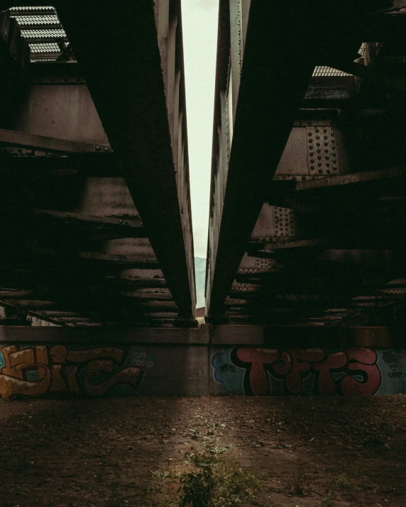 a picture of a train bridge with graffiti below