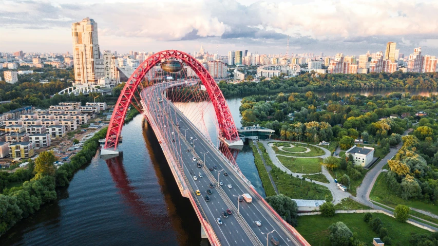 an aerial view of a bridge in the distance with a few cars traveling over it