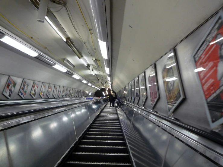 people riding an escalator on the side of a train