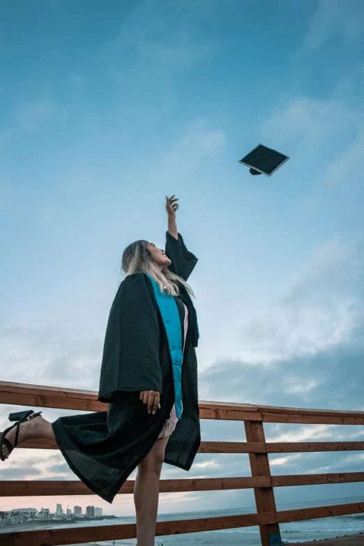 a girl in graduation outfit flying her hat