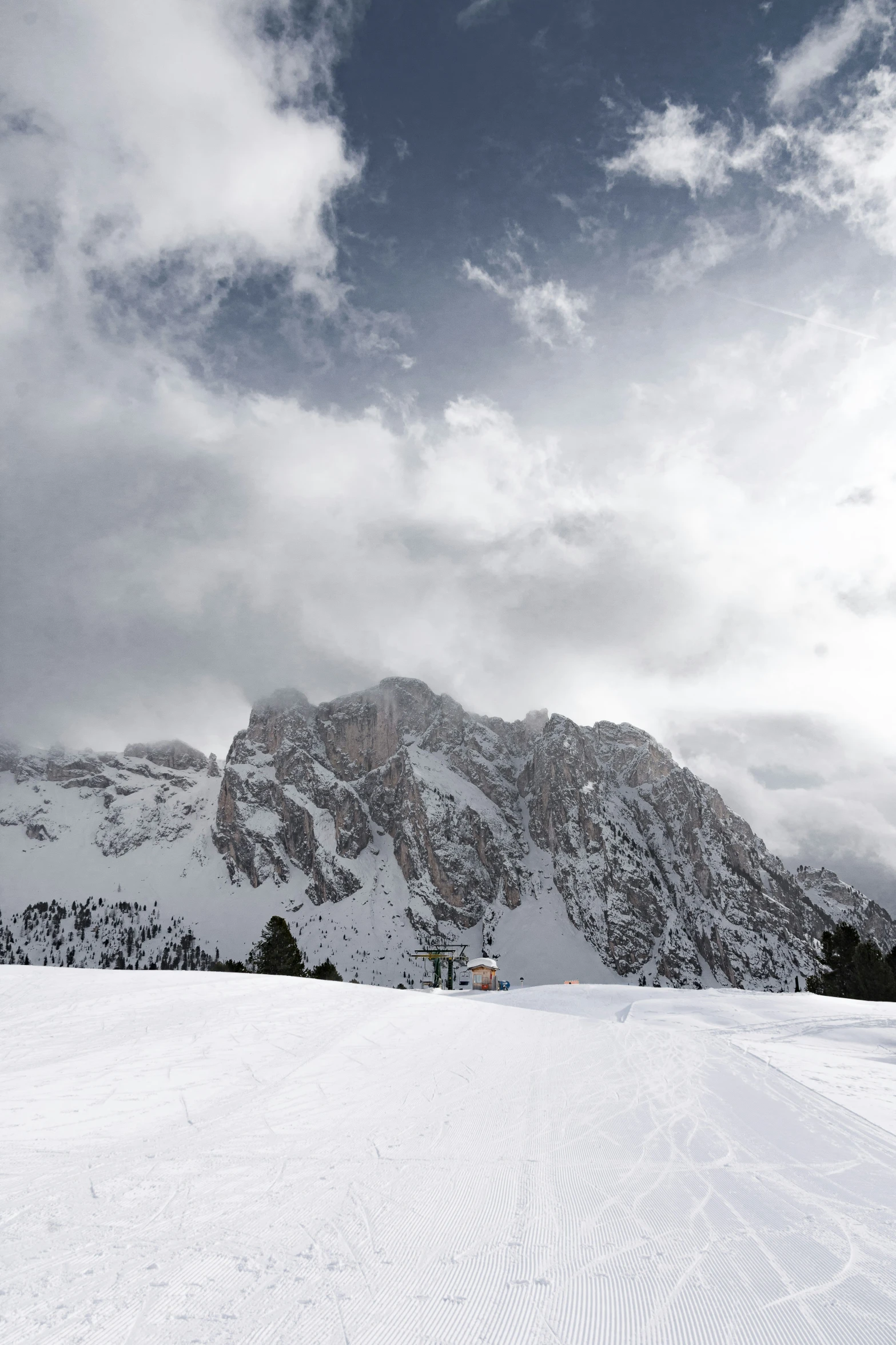 a group of skiers standing in the snow beneath a large mountain