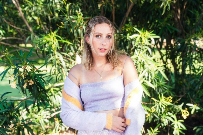 an attractive young woman in purple shirt posing for the camera