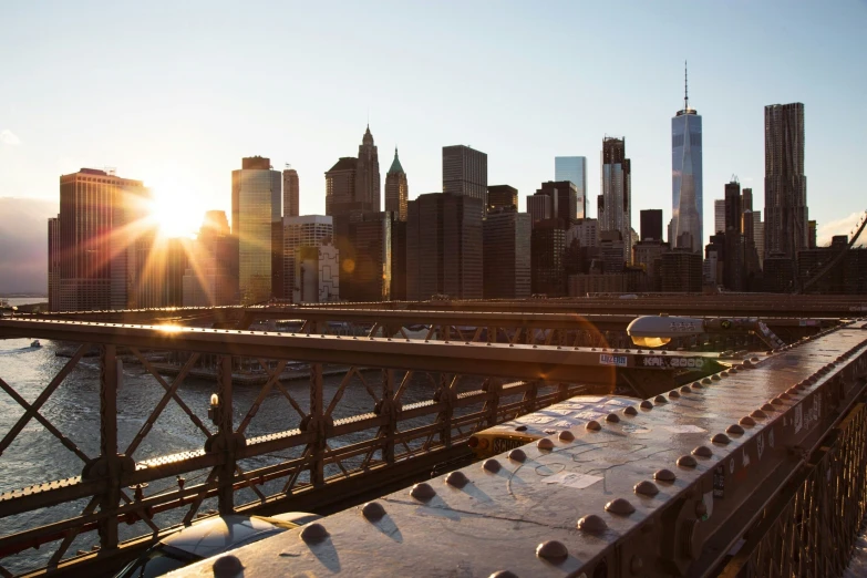 the sun shines down on a city from a bridge