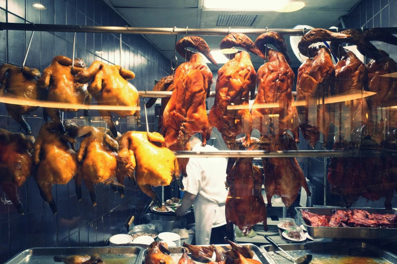 a large number of different types of raw chicken hanging up in the room