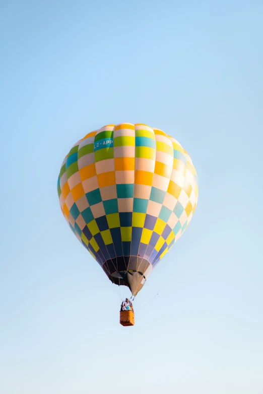 a colorful air balloon being held high by a string