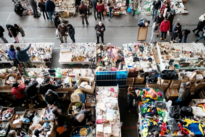 people walk around a market with many goods