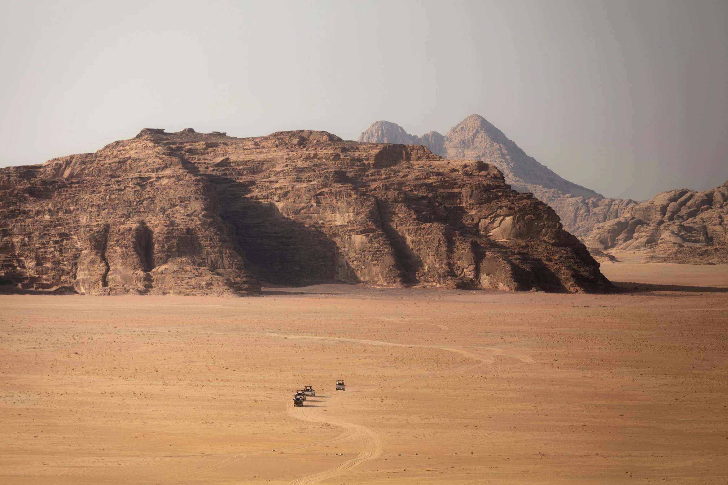 desert landscape with three horses parked in front of the rocks