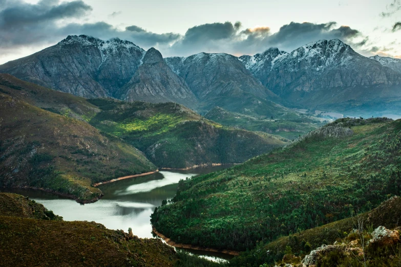 a view from a mountain top looking across a small river